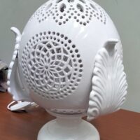 Lampada bianca decorativa a forma ovale.